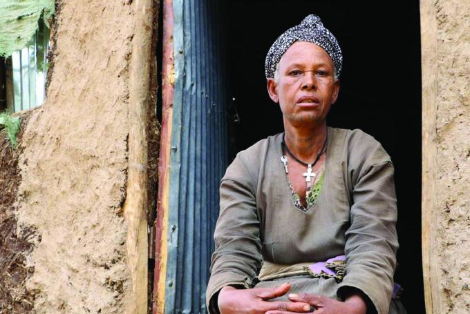  Guzguz, 52, a health promoter sitting outside her house in Ethiopia