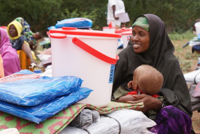 Shemso Abdi, 25, holds her Four years old son ,Abdiwehab , and sitting alongside the NFI and WASH kits she received from Save the Children, at Alewogarsi village in Kelafo district of the Somali Region.  
