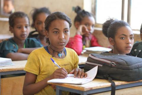 Zinash sitting in a classroom attending her lessons.